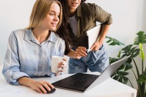 Two colleagues reviewing an Upwork account on a laptop