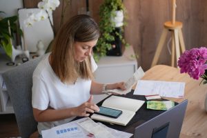 Freelancer checking receipts and a phone while reviewing earnings